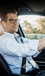 Professional man with glasses driving a car